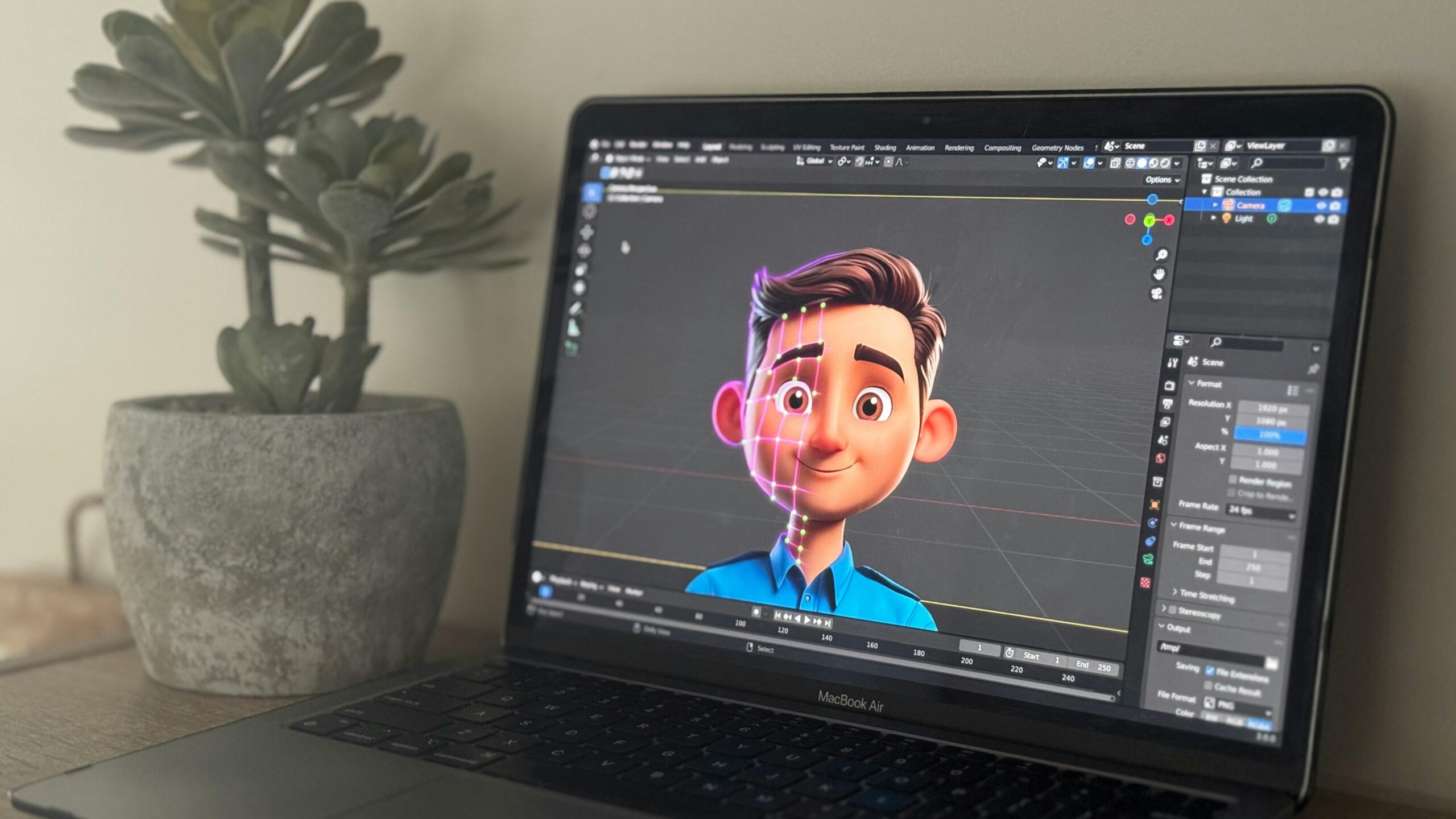 Home Laptop showing 3D animation in creative workspace with succulent plant.